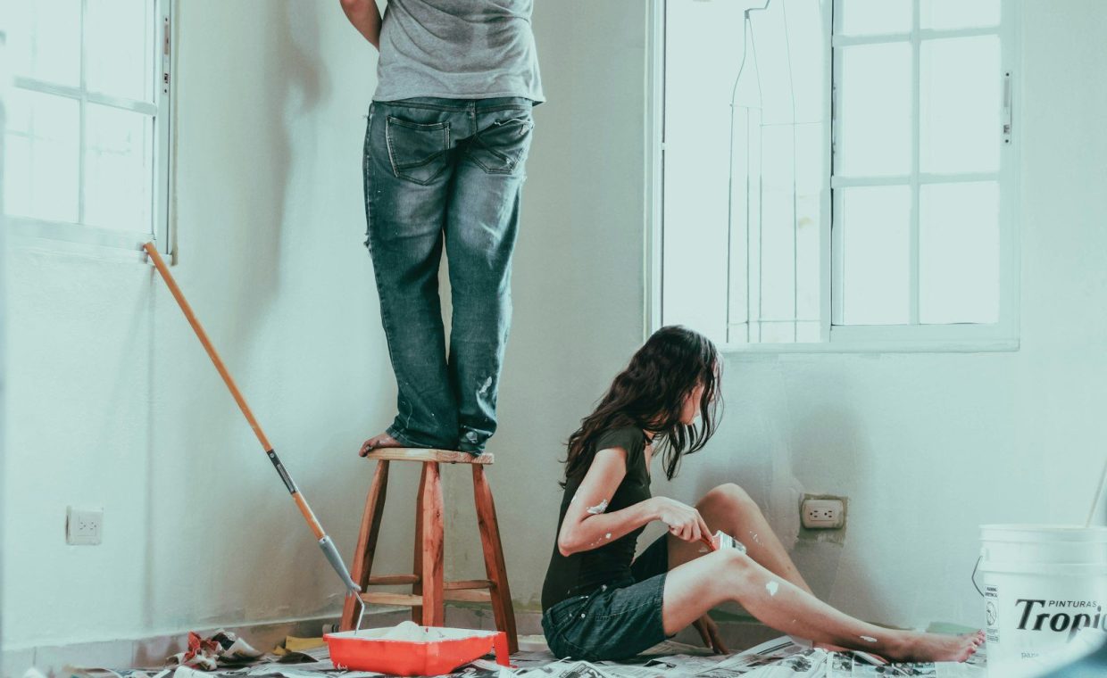 woman in gray tank top and blue denim jeans sitting on bed