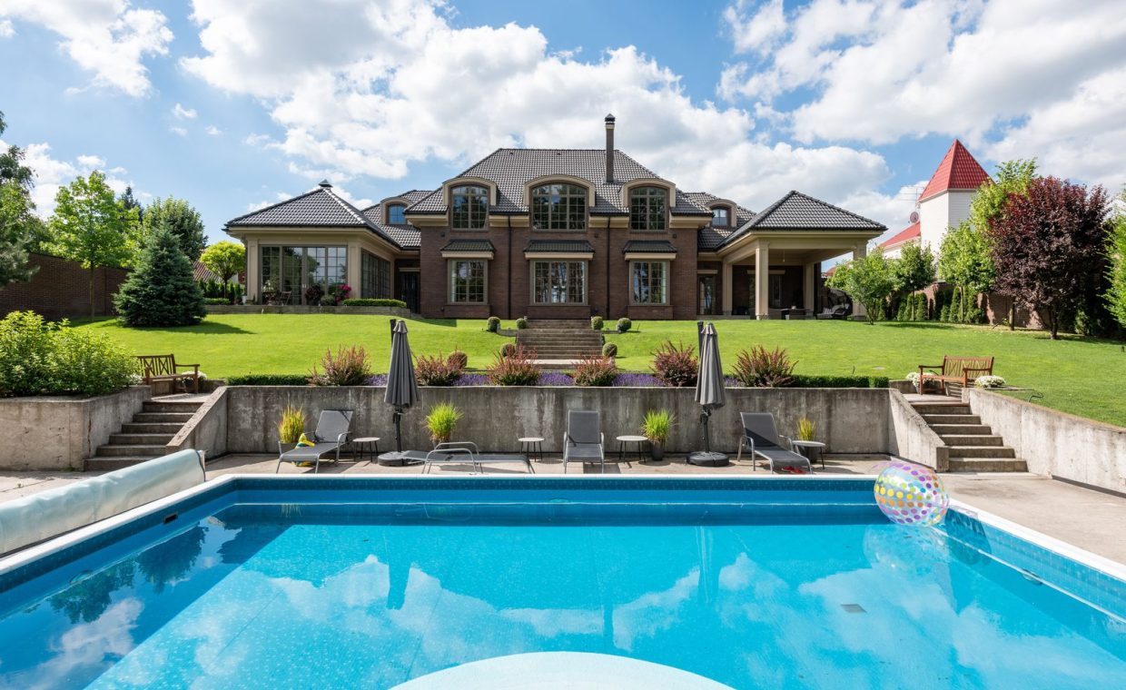 Elegant mansion with a sparkling pool and well-maintained garden, ideal for luxury living.