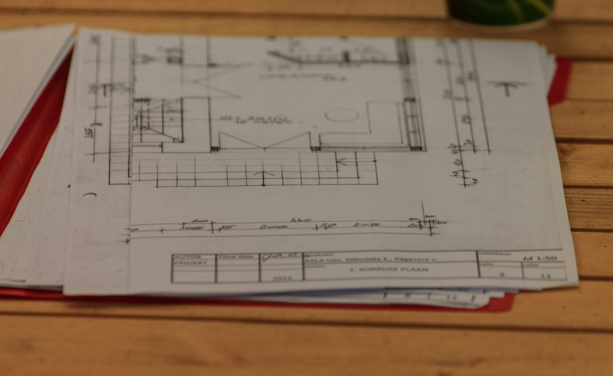 A wooden table topped with lots of papers