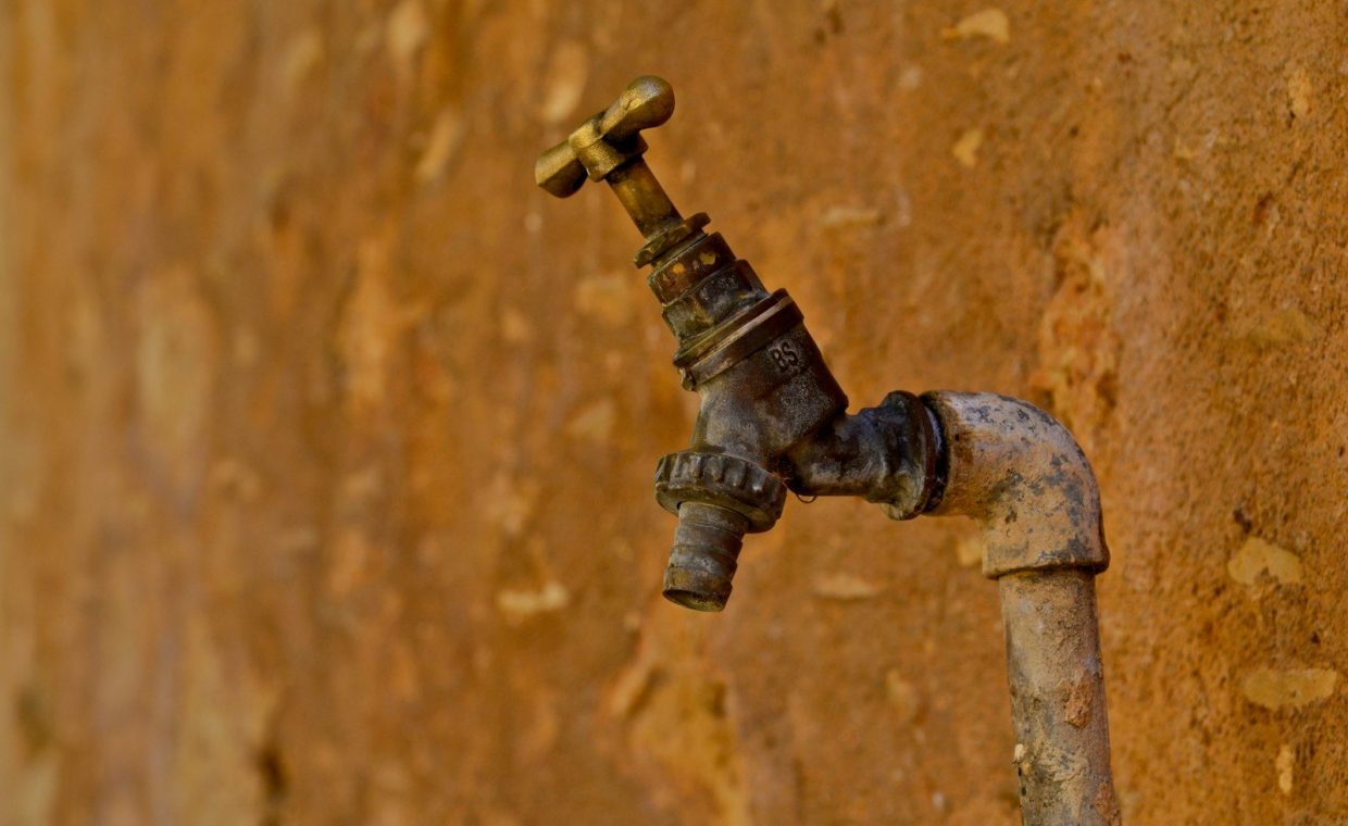 selective focus photography of brown faucet