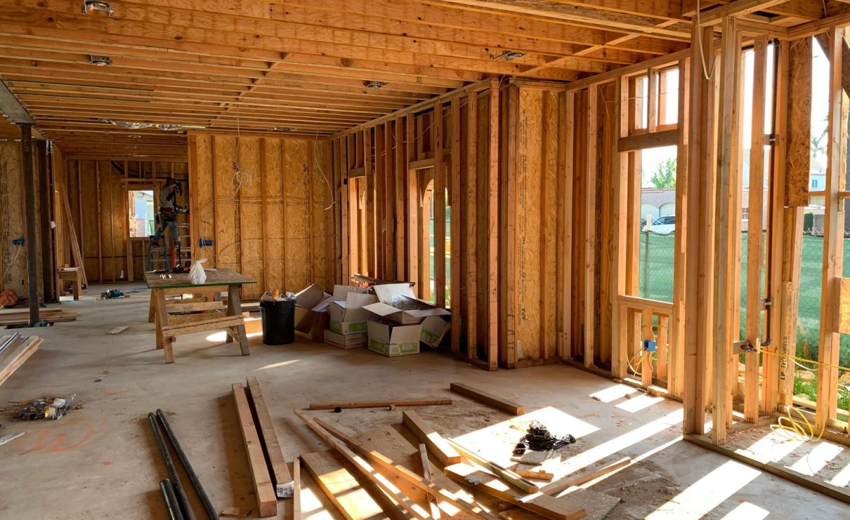 Sunlit interior with wood framing, showcasing home construction progress.