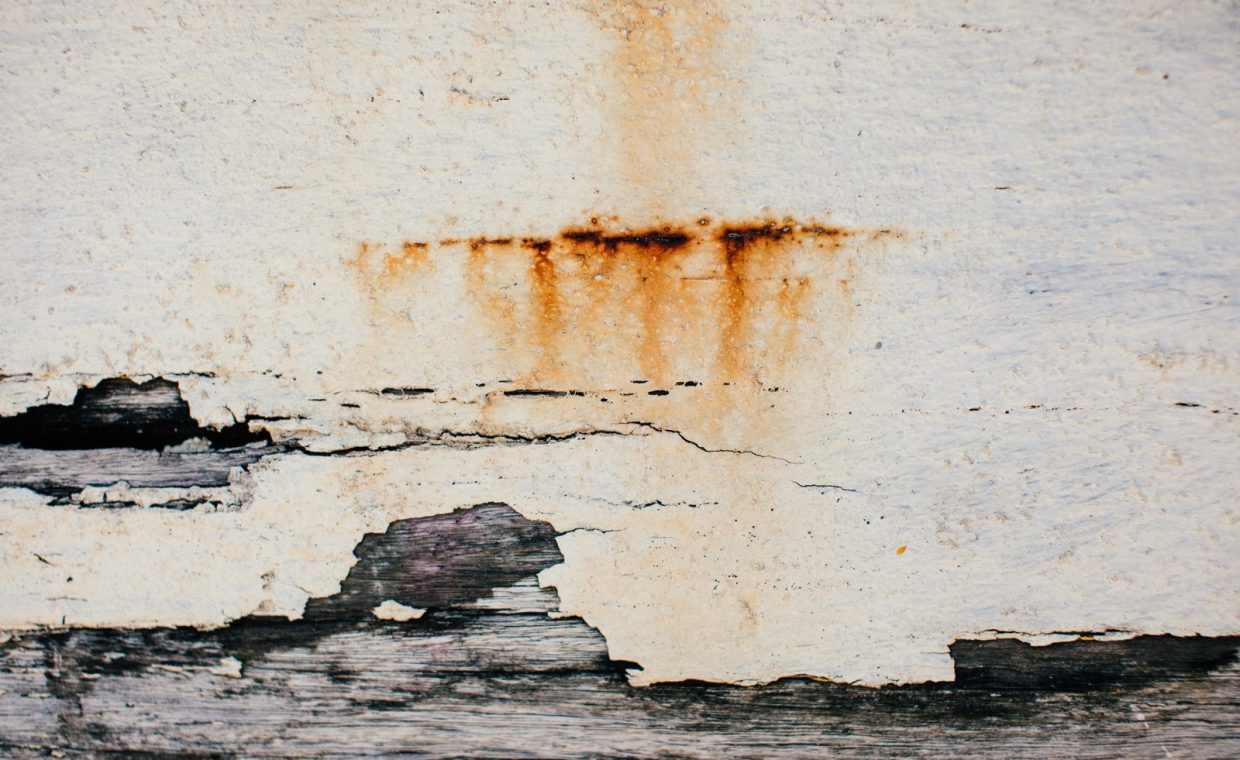 Textured background of weathered shabby cracked aged surface of old wall with plaster